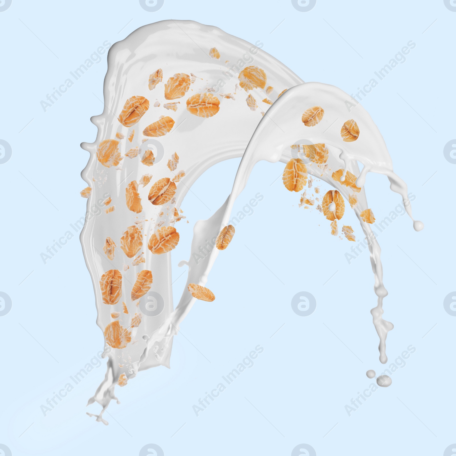 Image of Rolled oats and milk splash on light blue background