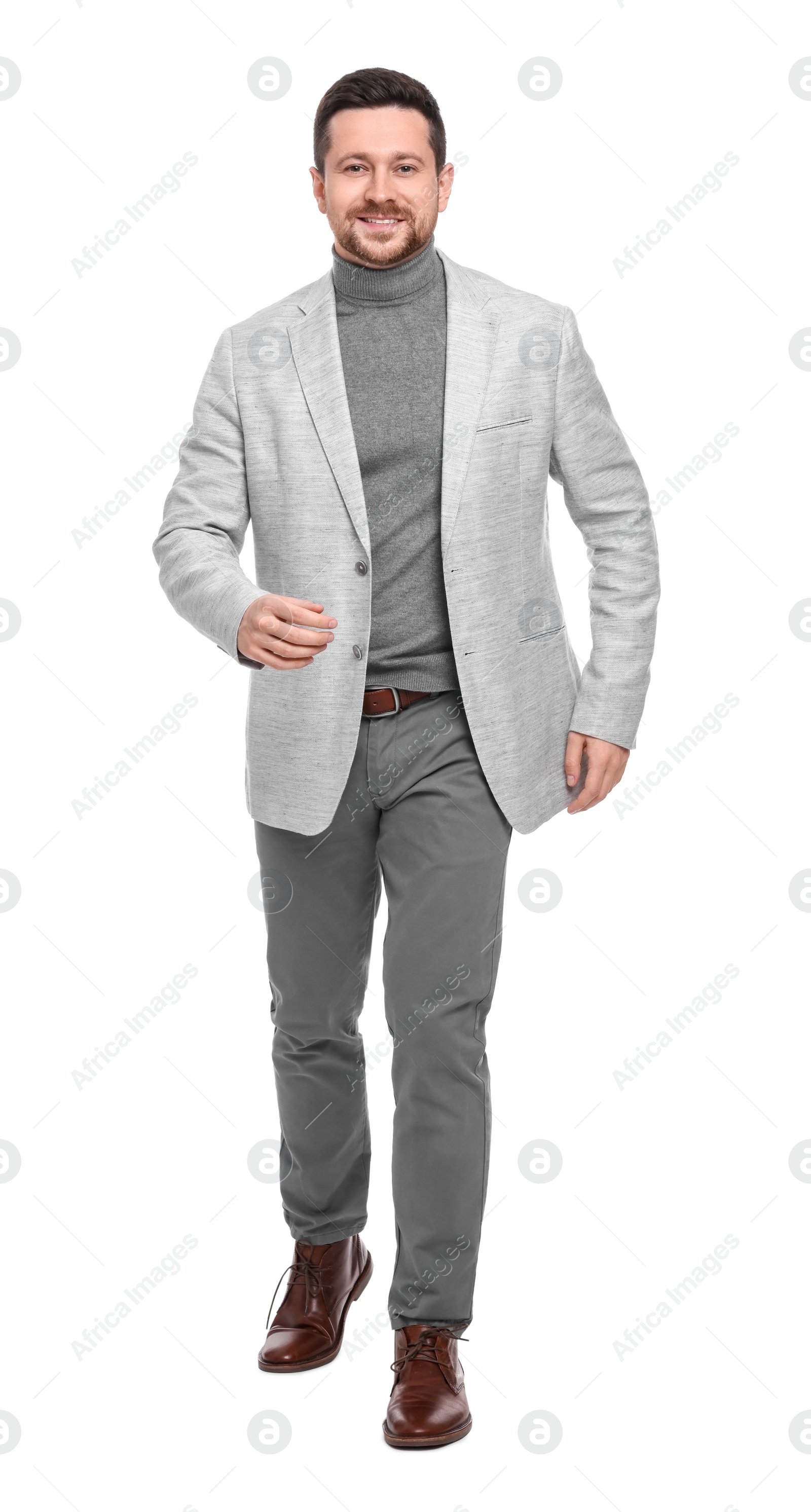 Photo of Handsome bearded businessman walking on white background