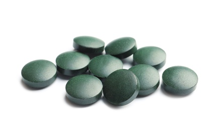 Photo of Spirulina tablets on white background. Healthy lifestyle