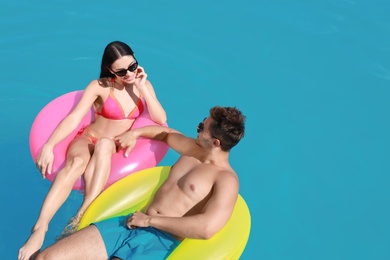 Photo of Woman in bikini with boyfriend swimming at resort. Happy young couple