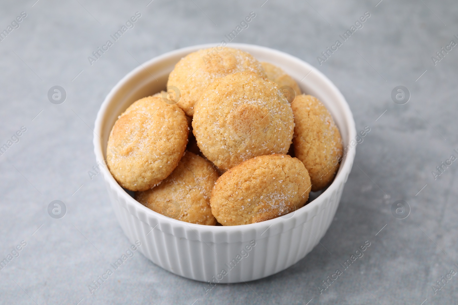 Photo of Tasty sugar cookies in bowl on grey table