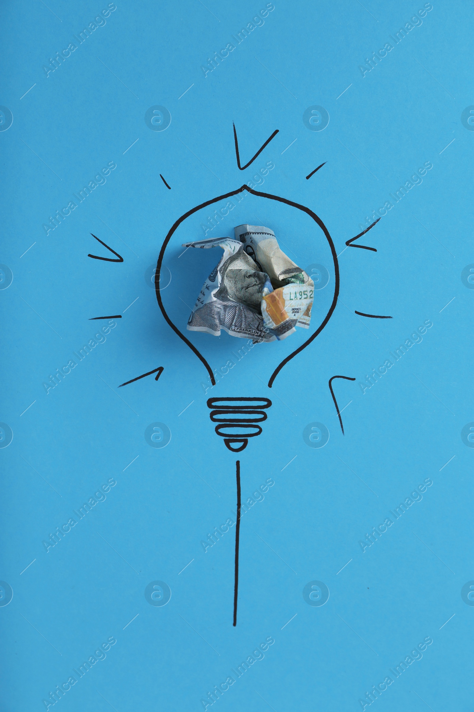 Photo of Composition with crumpled banknote and drawing of lamp bulb on color background, top view. Creative concept