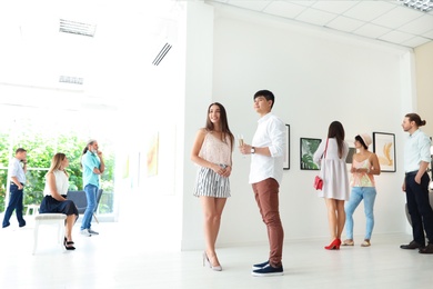 Photo of Young couple at exhibition in art gallery