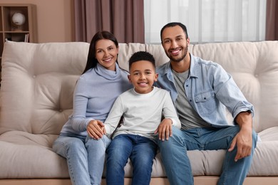 Photo of Happy international family on sofa at home