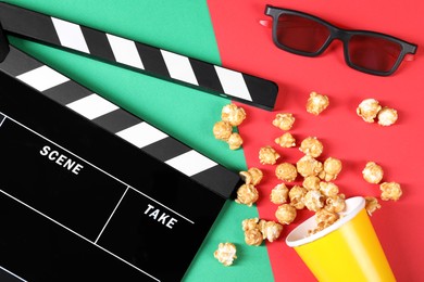 Photo of Clapperboard, popcorn and 3D glasses on color background