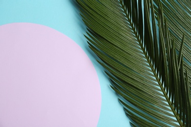 Photo of Blank card with tropical leaves on color background, top view