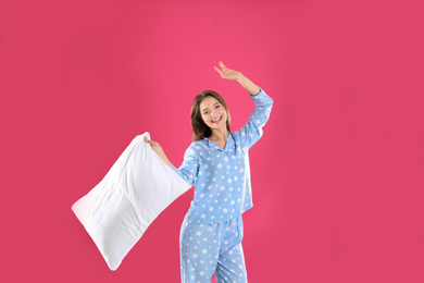 Photo of Young woman with pillow on pink background