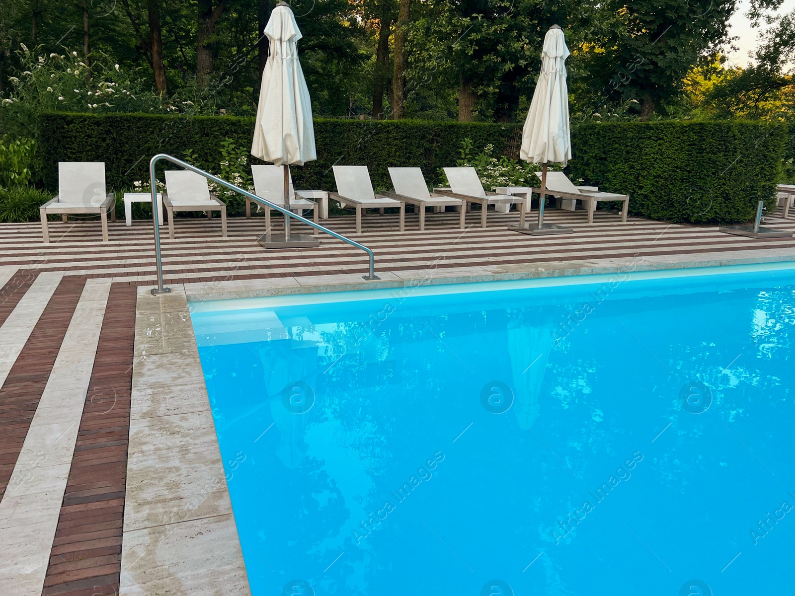 Photo of Outdoor swimming pool in luxury hotel on sunny summer day. Time for relax