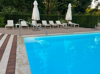 Photo of Outdoor swimming pool in luxury hotel on sunny summer day. Time for relax