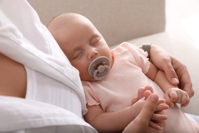 Mother with her cute sleeping baby at home, above view