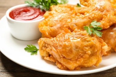Tasty deep fried chicken pieces served on table, closeup