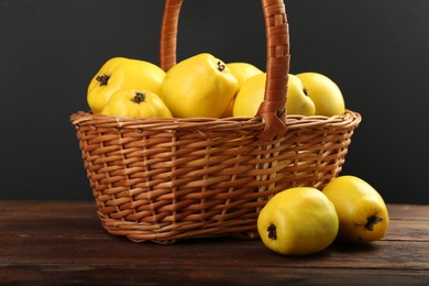 Basket with delicious ripe quinces on wooden table