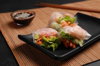 Photo of Tasty spring rolls served with soy sauce on grey table, closeup