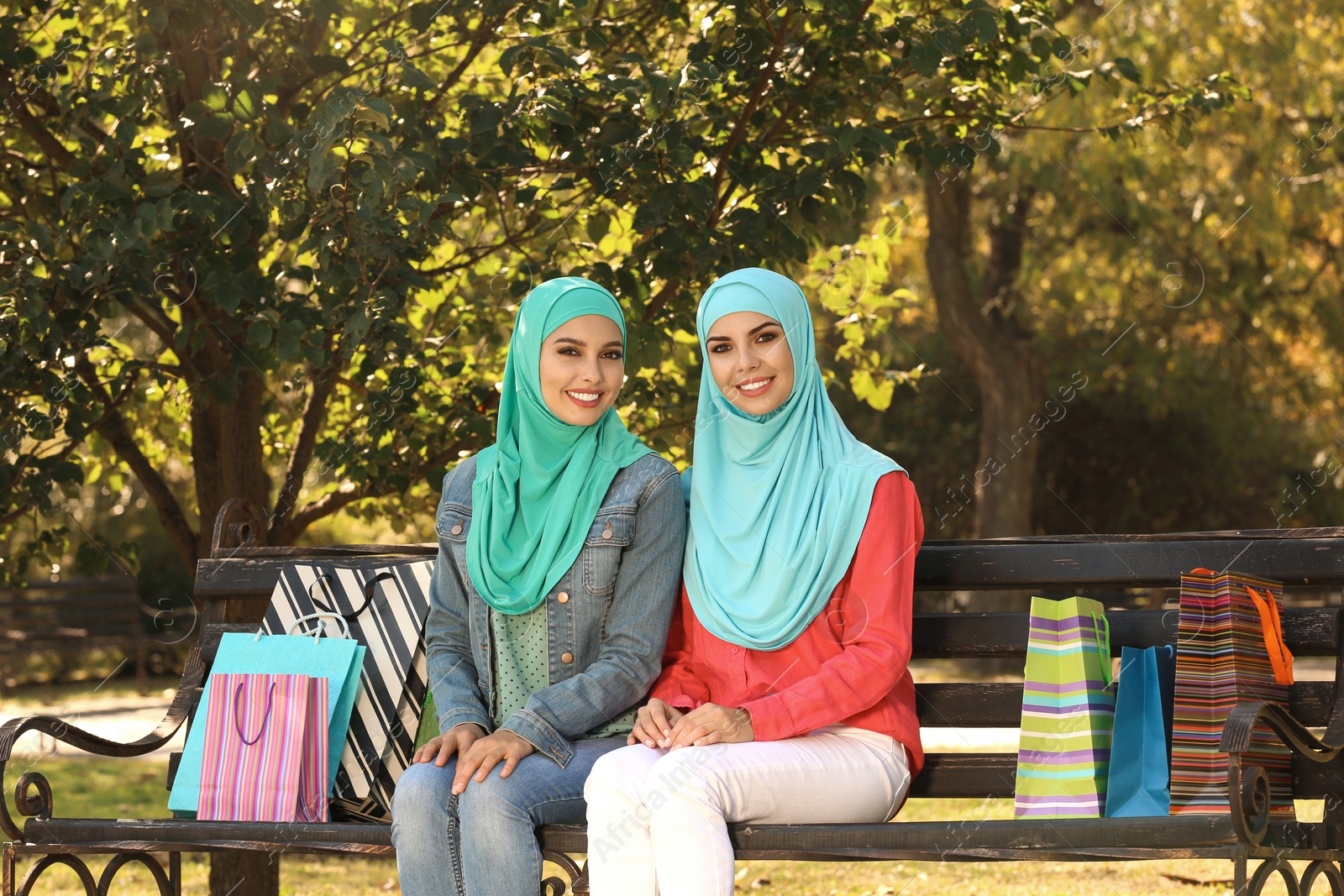 Photo of Muslim women sitting on bench in park