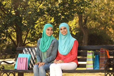 Muslim women sitting on bench in park