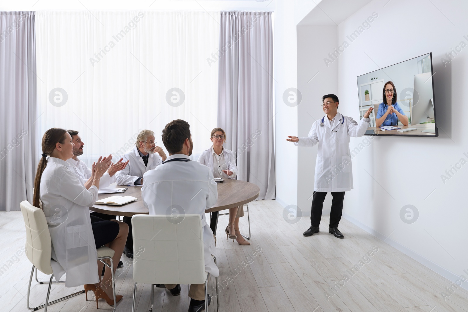 Image of Lecture with online participant. Doctors in meeting room. Using tv for videoconference