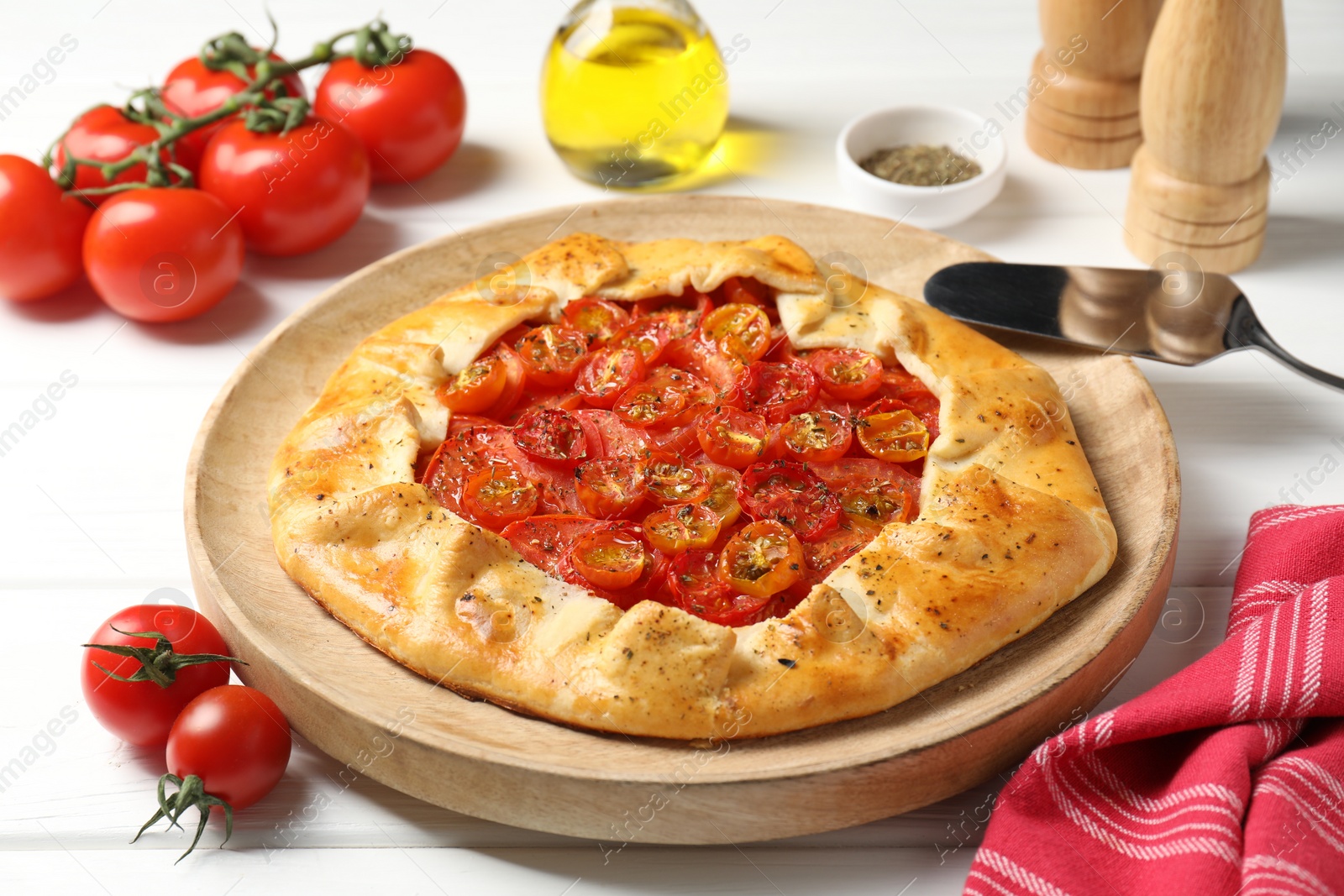 Photo of Tasty tomato galette (Caprese galette) on white wooden table, closeup