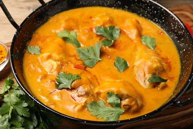 Tasty chicken curry with parsley on table, closeup