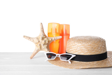 Composition with sun protection products on wooden table against white background