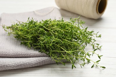 Bunch of aromatic thyme on white wooden table, closeup