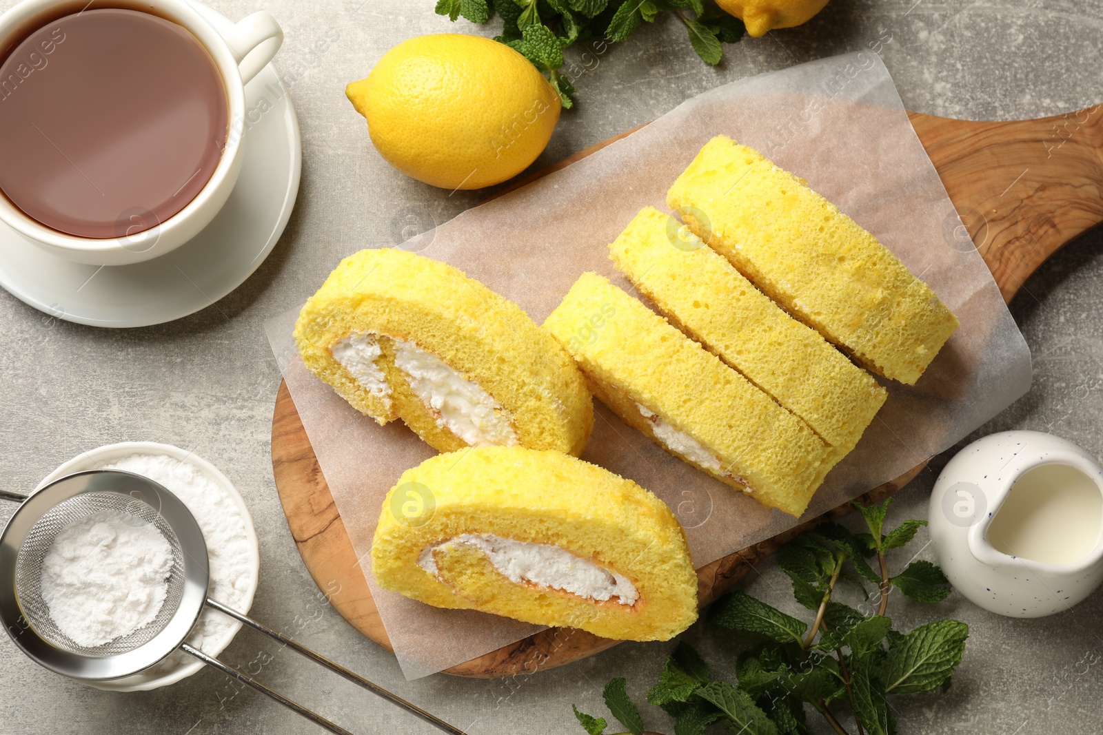 Photo of Delicious cake roll served on grey table, flat lay