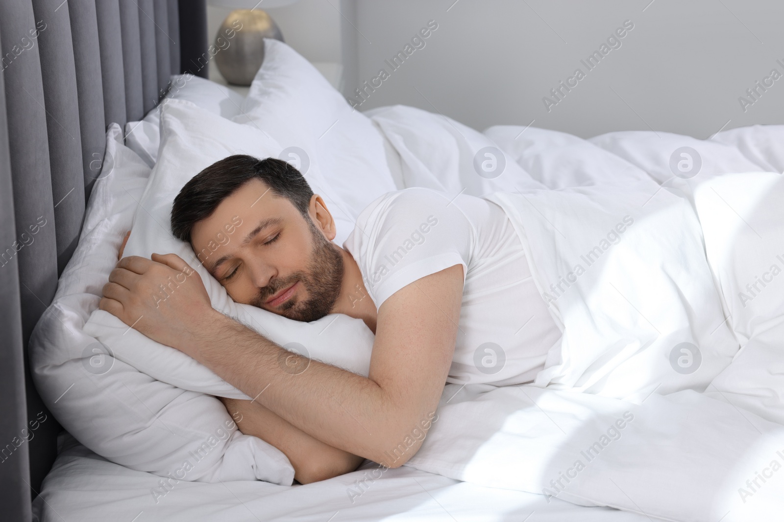 Photo of Handsome man sleeping in soft bed at home