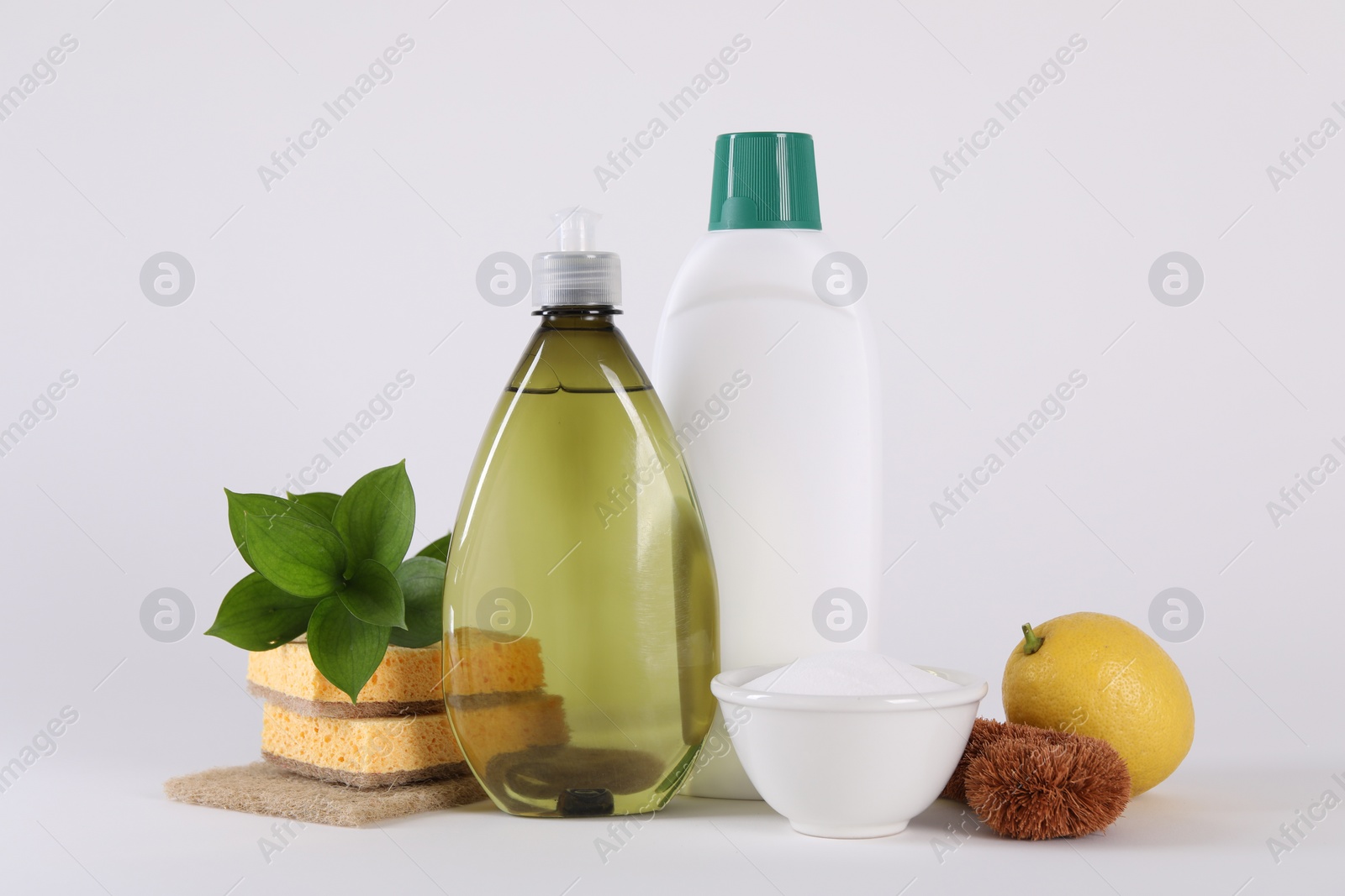 Photo of Bottles of cleaning product, brush, sponges and lemon isolated on white