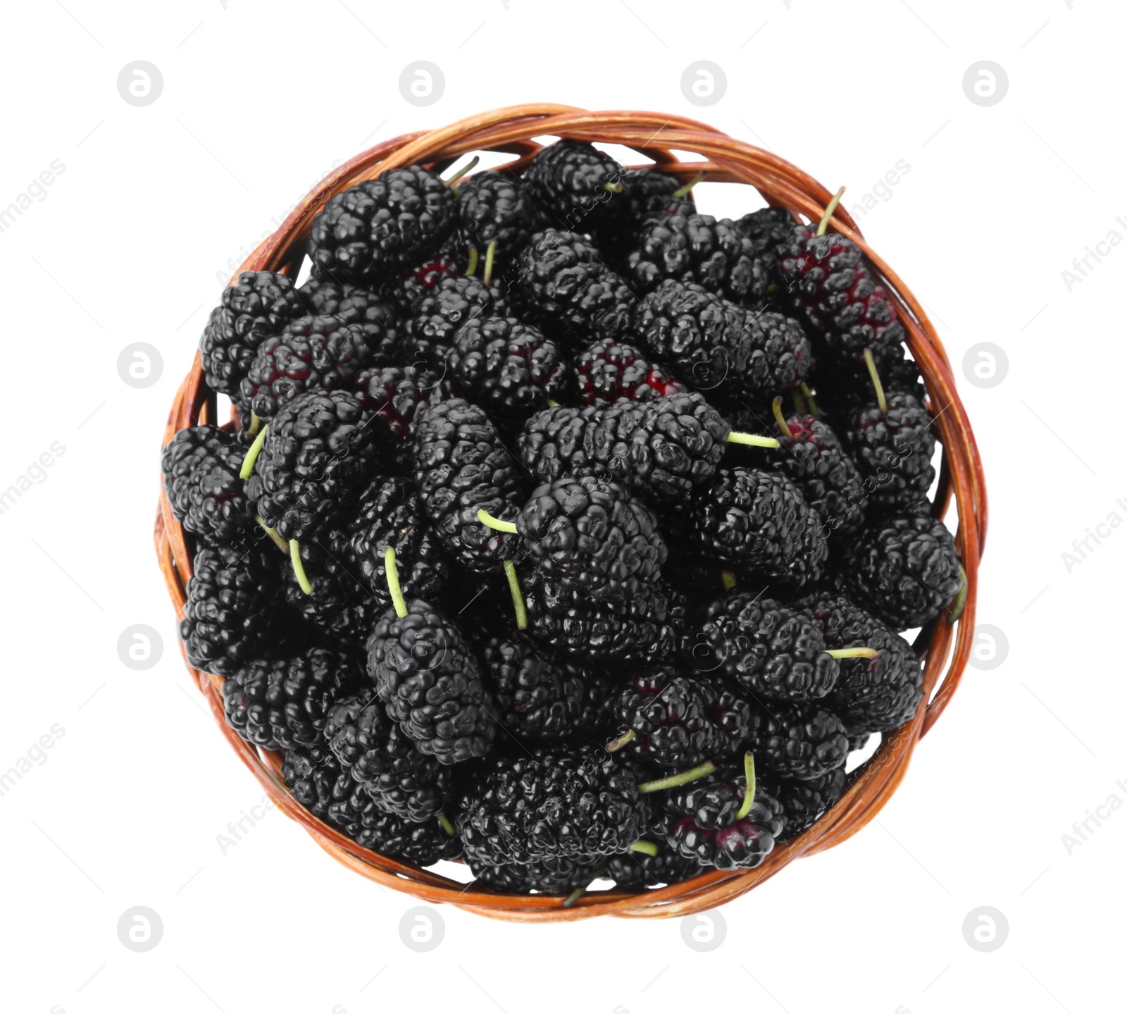 Photo of Ripe black mulberries in wicker bowl on white background, top view