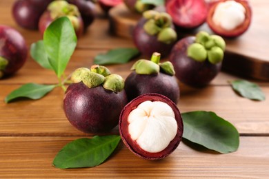 Photo of Fresh ripe mangosteen fruits on wooden table