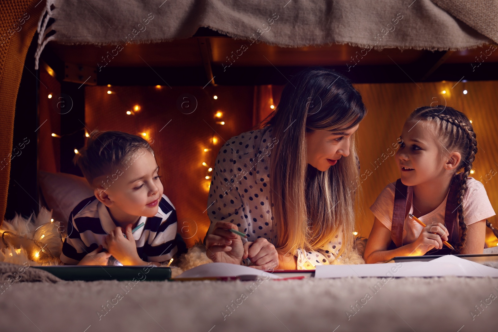 Photo of Mother and her children drawing in play tent at home