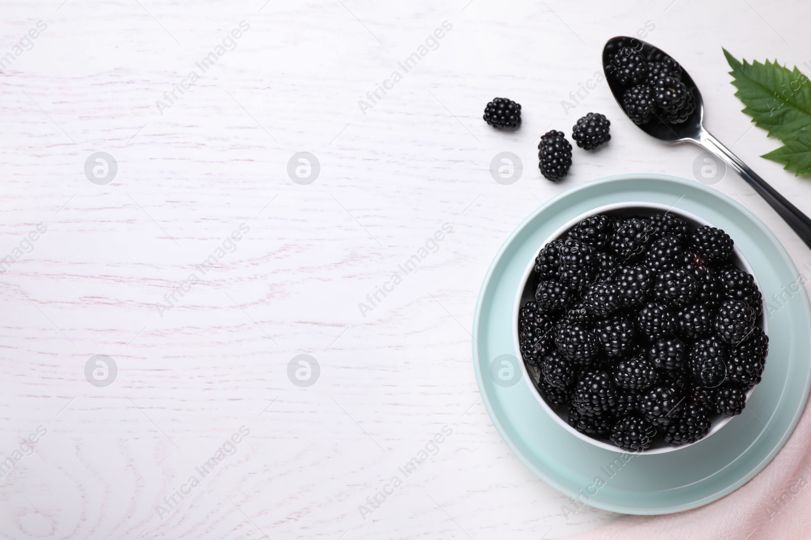 Photo of Flat lay composition with fresh ripe blackberries on white wooden table. Space for text