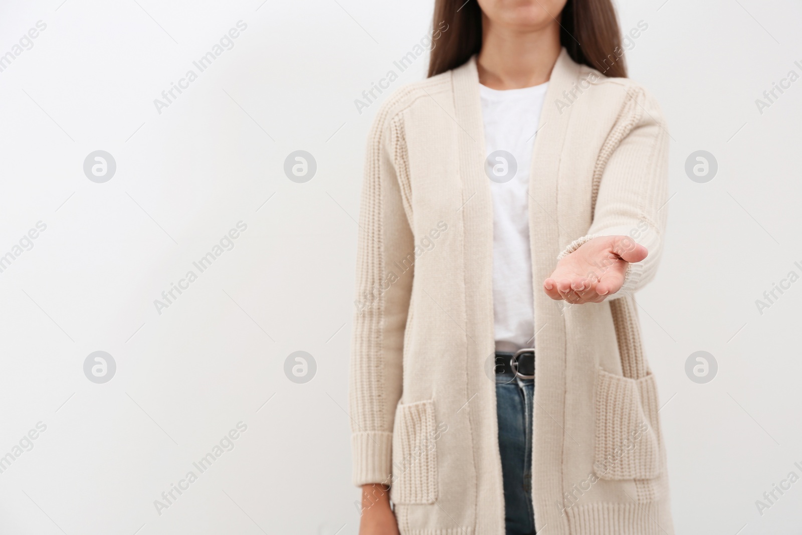 Photo of Woman giving helping hand on light background. Space for text