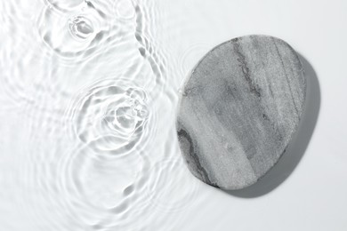 Photo of Presentation of product. Stone podium in water on white background, top view. Space for text