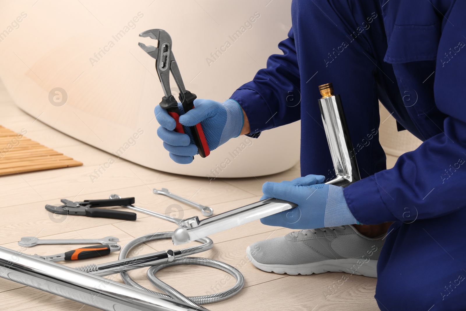 Photo of Professional plumber installing water tap in bathroom, closeup