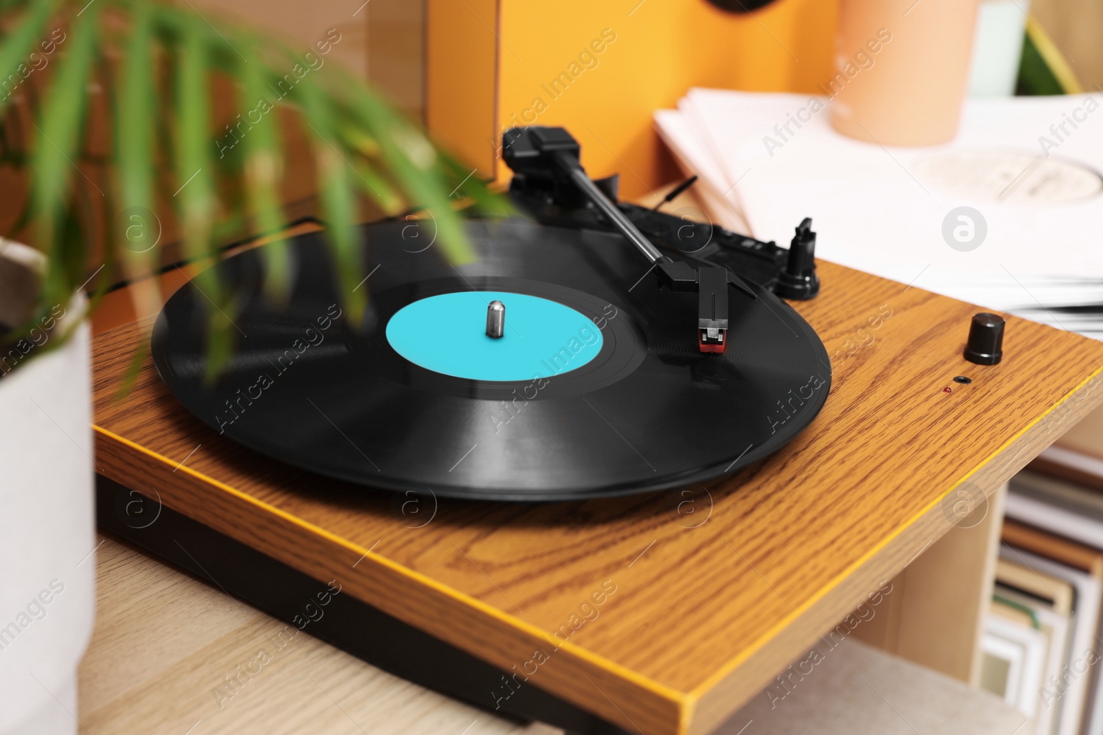 Photo of Stylish turntable with vinyl record on table indoors