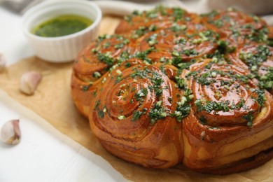 Photo of Traditional Ukrainian garlic bread with herbs (Pampushky) on white wooden table, closeup