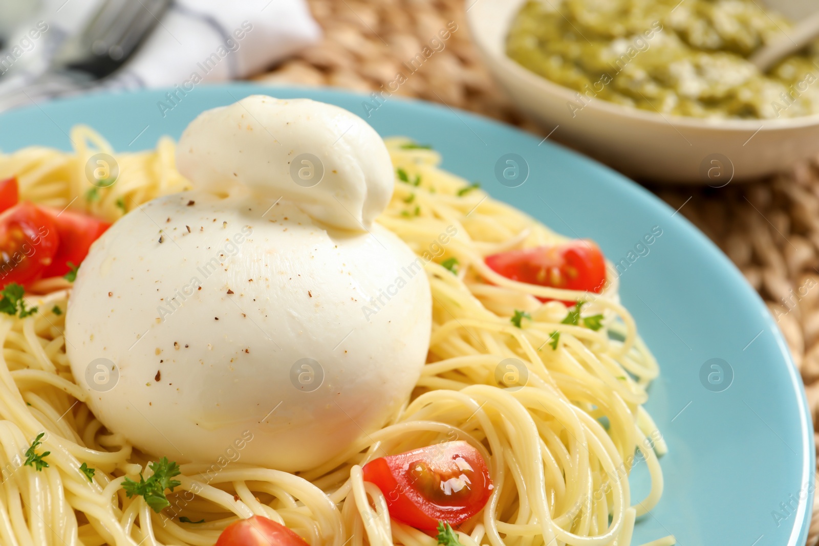 Photo of Plate of delicious pasta with burrata and tomatoes on table, closeup