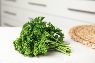 Photo of Bunch of fresh green parsley on table indoors
