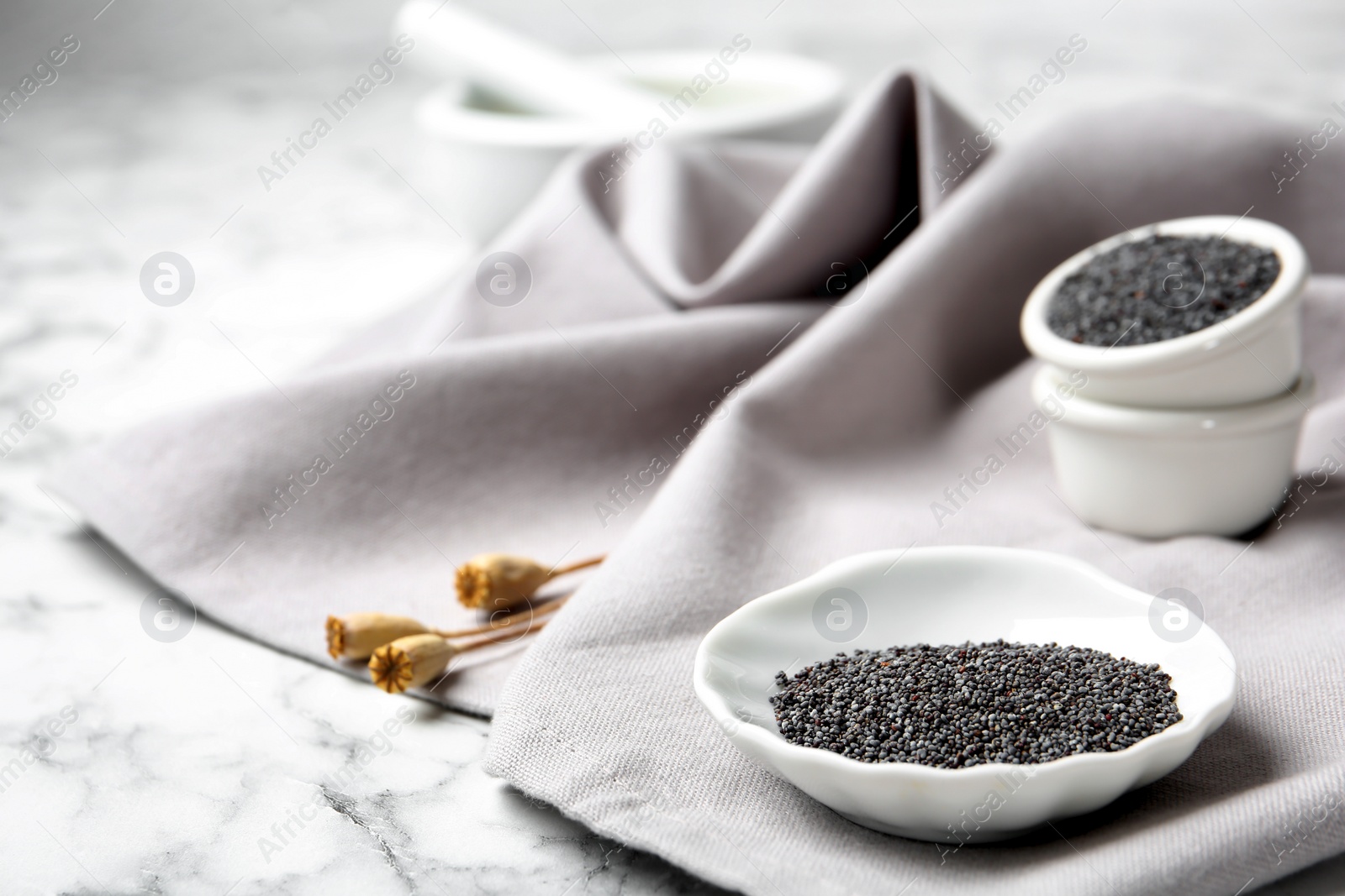 Photo of Composition with poppy seeds on grey fabric