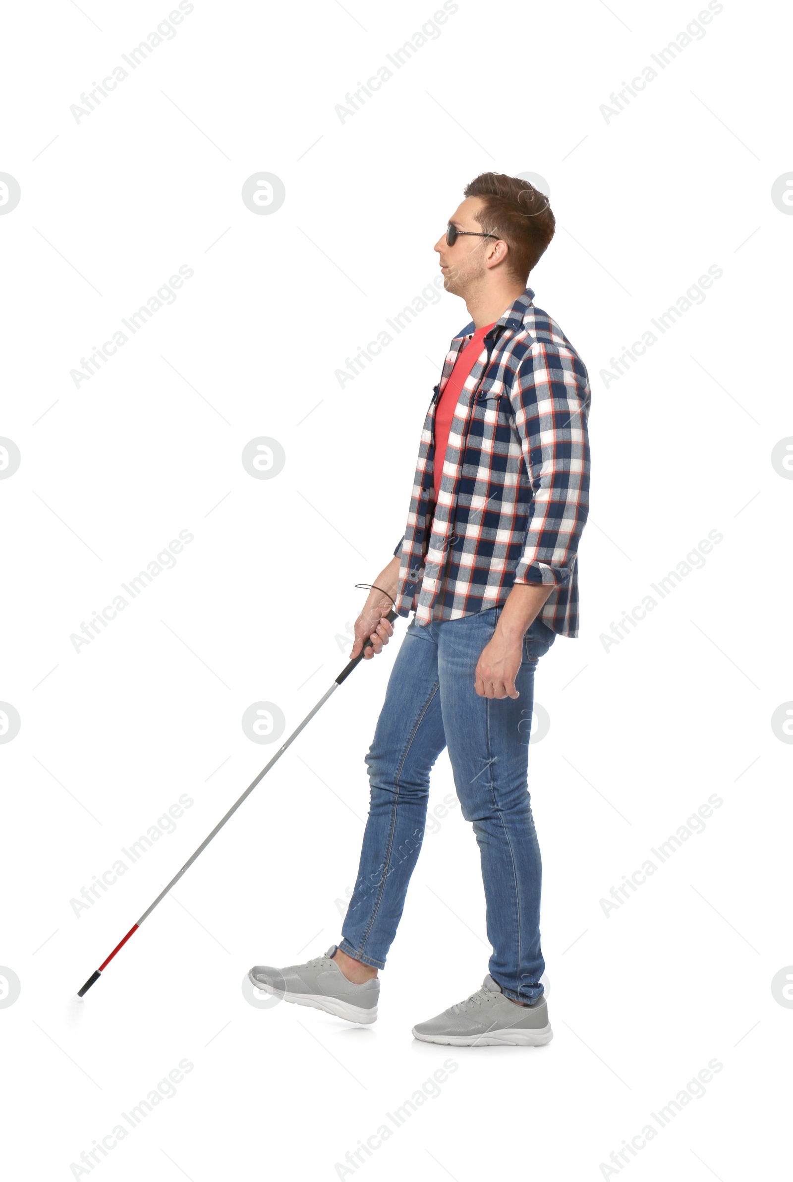 Photo of Young blind person with long cane walking on white background