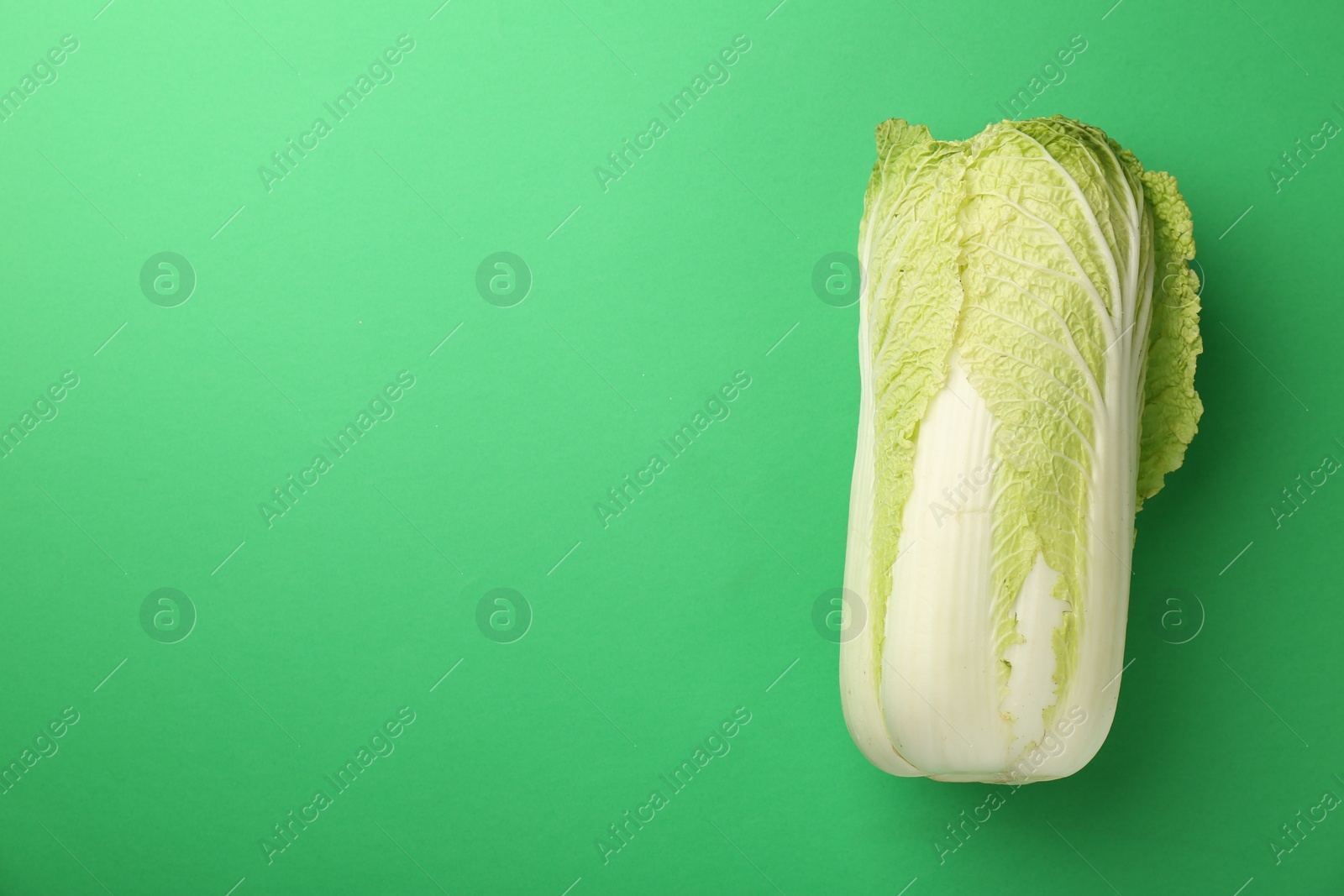 Photo of Fresh ripe Chinese cabbage on green background, top view. Space for text