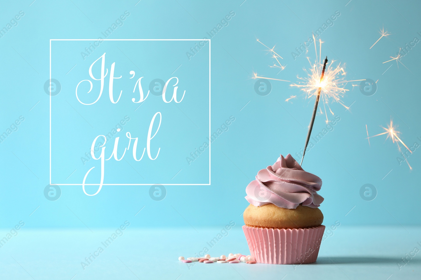 Image of Baby shower cupcake with sparkler for girl on light blue table