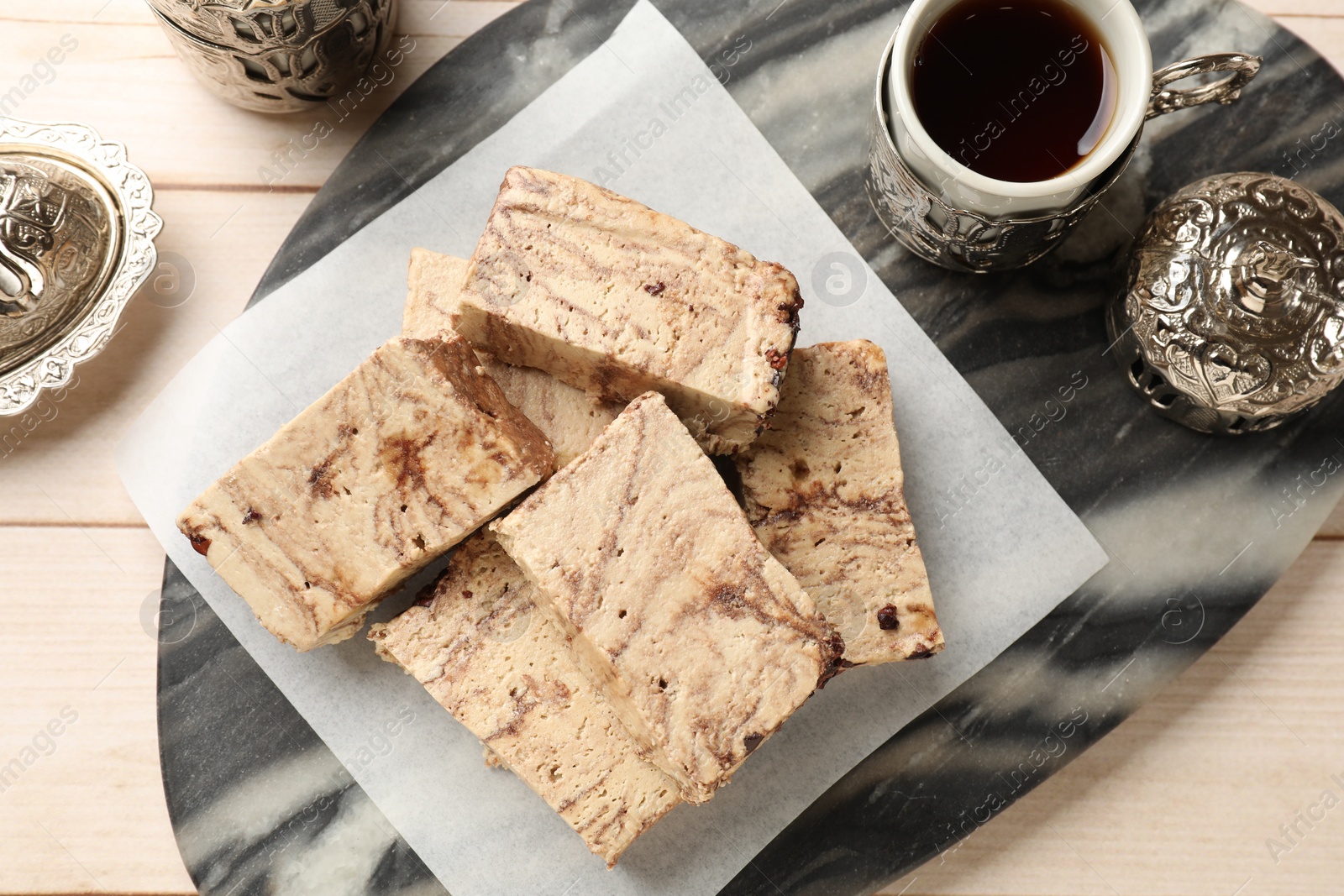 Photo of Tasty chocolate halva served on wooden table, top view