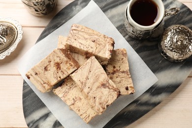 Photo of Tasty chocolate halva served on wooden table, top view