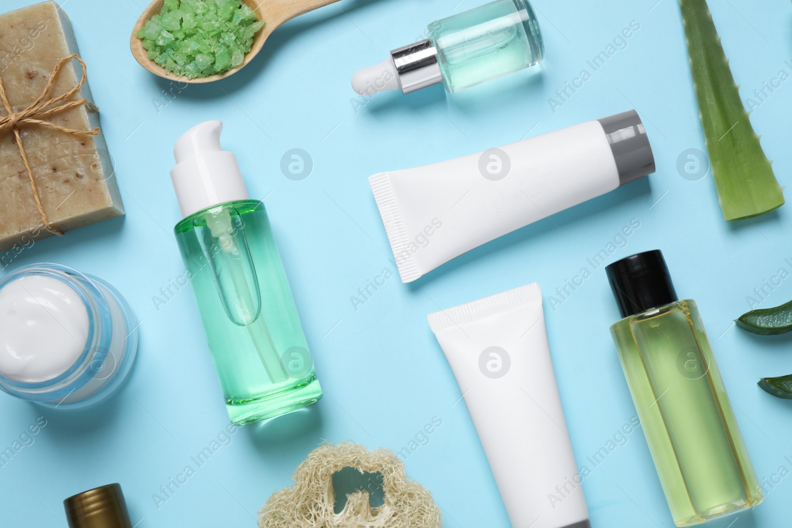 Photo of Flat lay composition with aloe vera and cosmetic products on light blue background