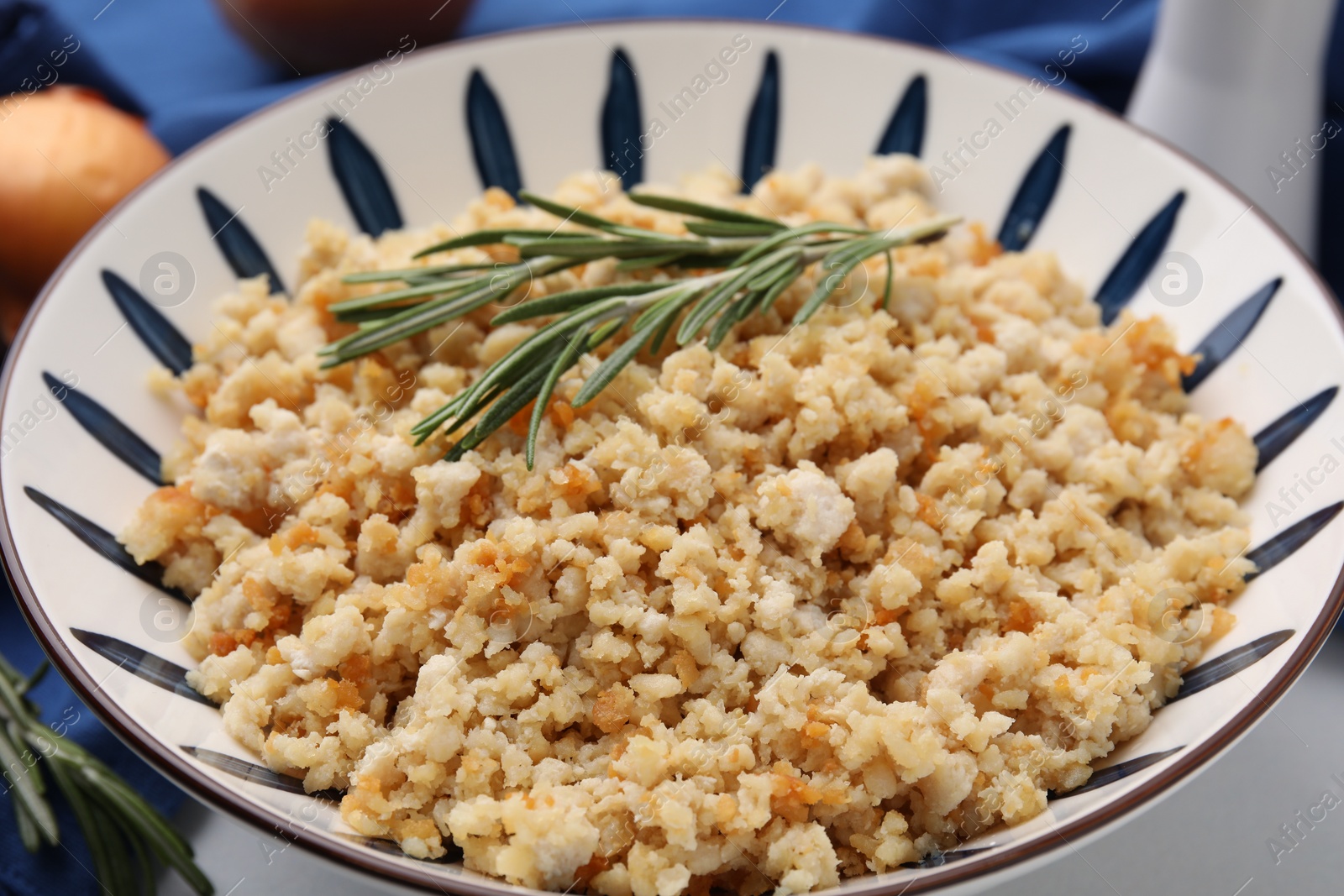 Photo of Fried ground meat in bowl and rosemary on table, closeup