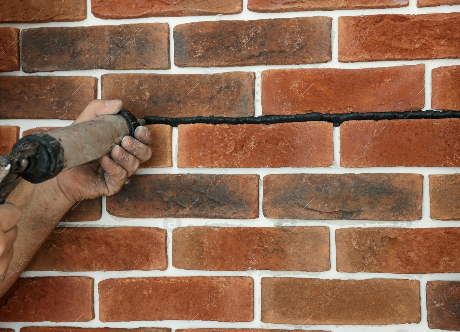 Photo of Professional builder using tiling fugue for grouting, closeup