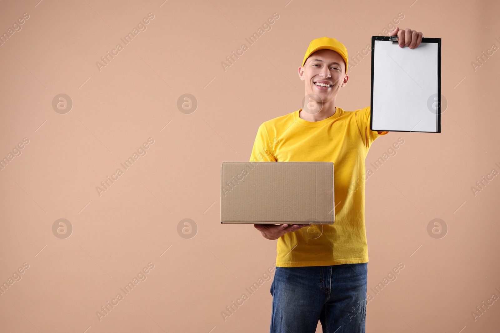 Photo of Happy courier with parcel and clipboard on beige background. Space for text