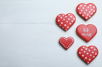 Photo of Delicious heart shaped cookies on white wooden table, flat lay with space for text. Valentine's Day