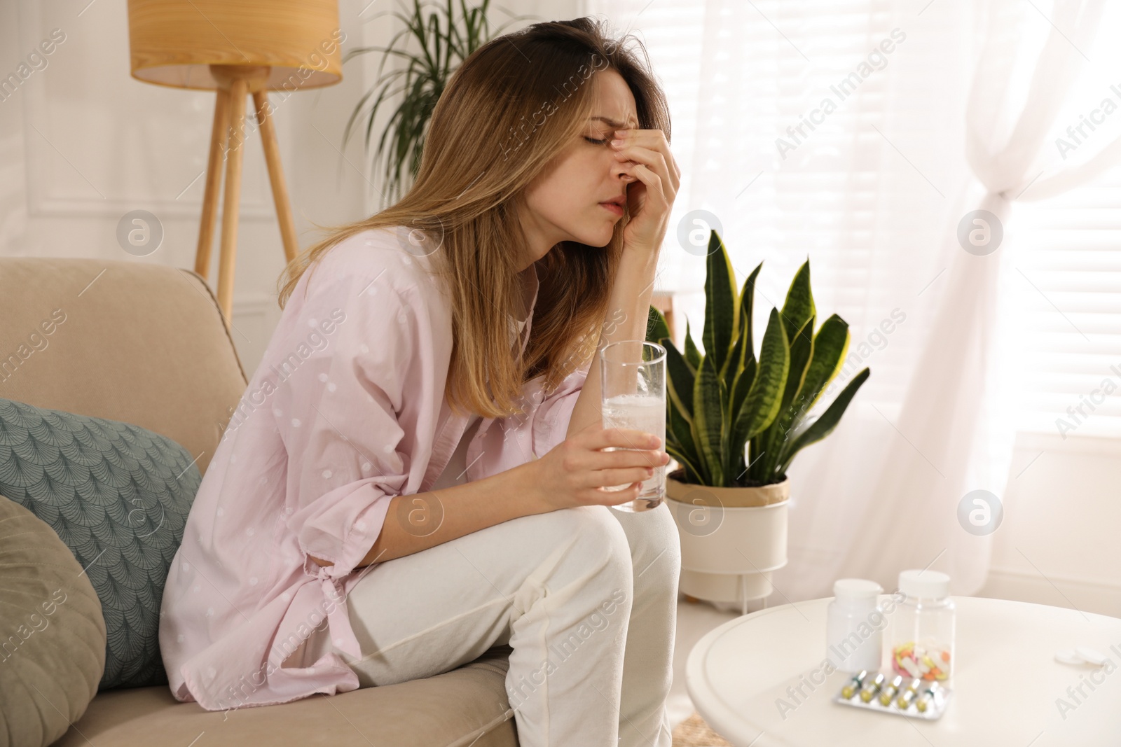 Photo of Woman holding glass of medicine for hangover at home